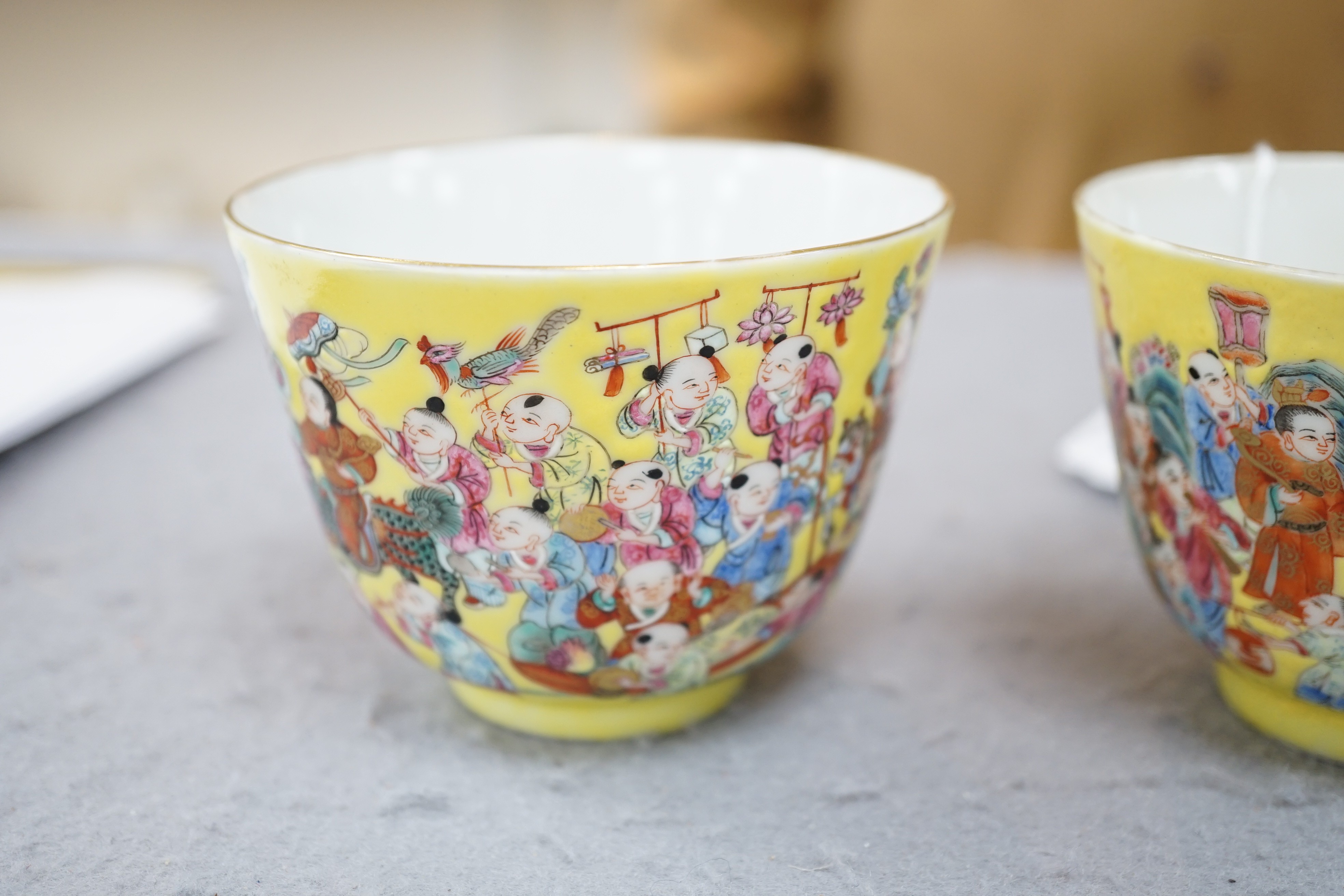 A pair of Chinese yellow ground 'Hundred Boys’ cups, 19th century, 6.5cm high 8.5cm diameter